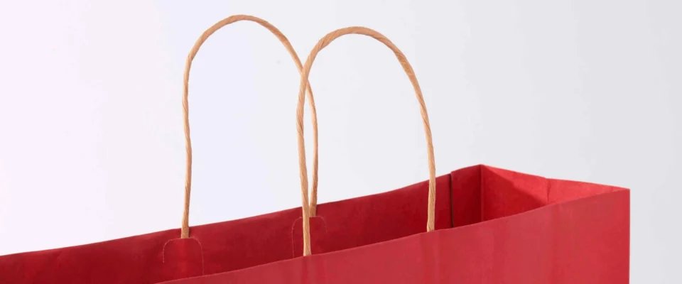 Red paper gift bag with brown paper handles.
